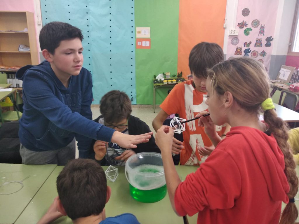 Alumnes de l'escola Cèsar August posant en pràctica un dels experiments.