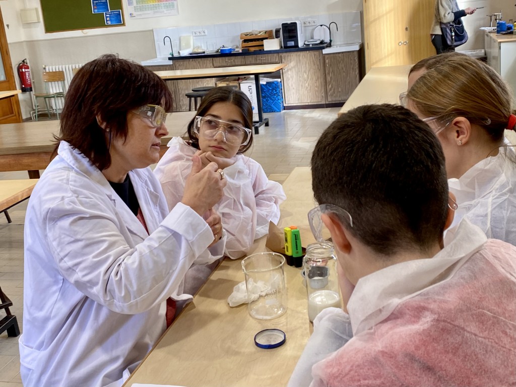 Una madrina científica amb el seu equip d’alumnes preparant un experiment. 