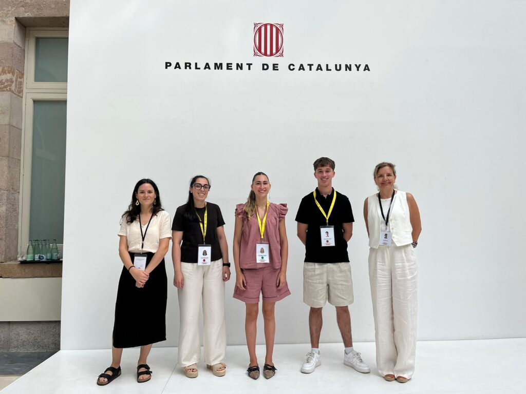 Les professores Clara Esteve i Laura Román (a l'esquerra i la dreta, respectivament) amb els tres estudiants participants a la Setmana del Parlament Universitari 2026, Anna Pérez, Julia Villegas i Marc García.